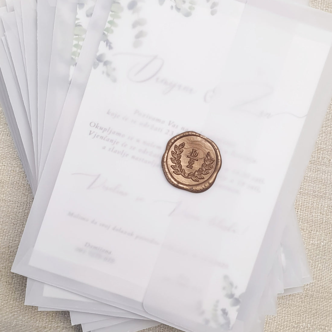 Personalizirane pozivnice za vjenčanje s svevremenskim dizajnom printane na teksturiranom visoko kvalitetnom papiru u prozirnoj kuverti zatvorene s voštanim pečatom s utisnutim inicijalima. 